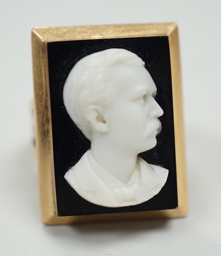 A yellow metal and black sardonyx set rectangular cameo ring, carved with the bust of a gentleman to sinister, size L, gross weight 12.6 grams.